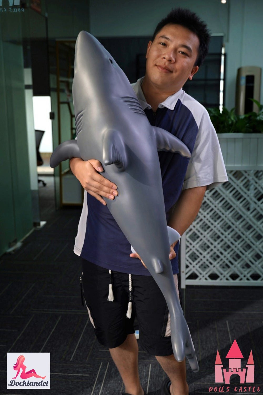 Lalka Shark 110 cm trzymana w ramionach, aby pokazać rozmiar i proporcje, realistyczny wygląd rekina z szarą górą i białym dołem.